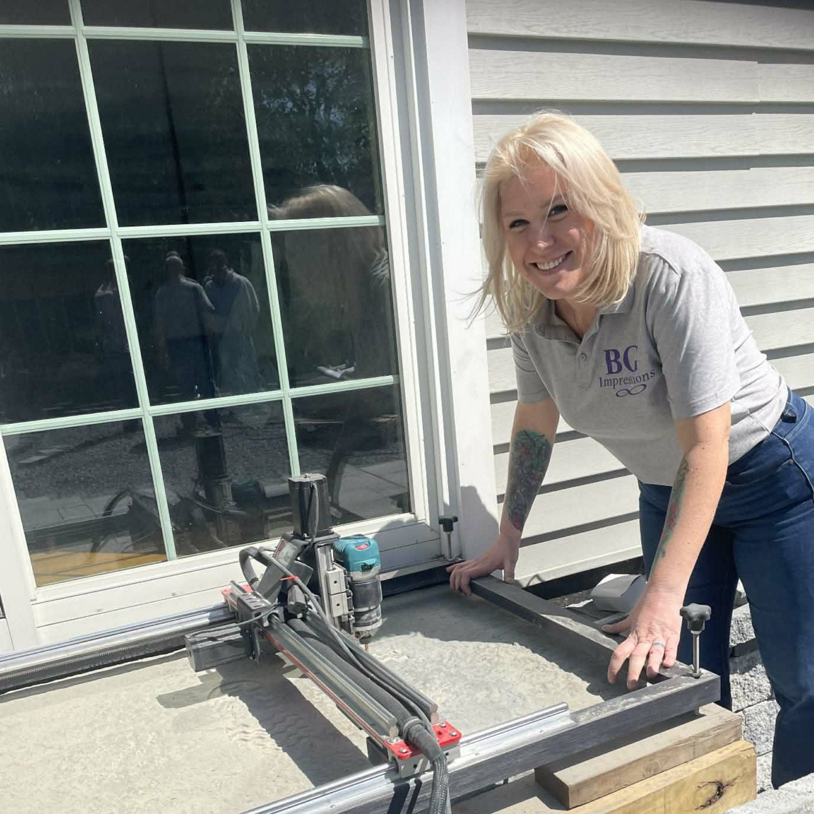 BG Impressions team member operating the engraving machine on-site